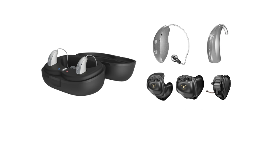 Open charging case with two wireless earbuds inside; several hearing-aid components and domes laid out nearby (ear molds, BTE parts).
