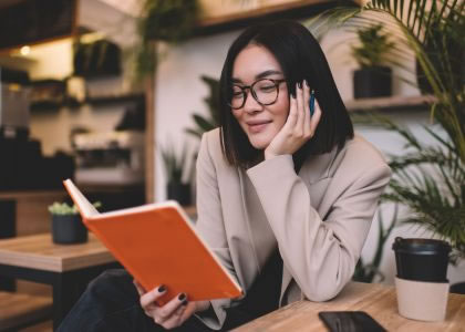 Woman in glasses reading a notebook