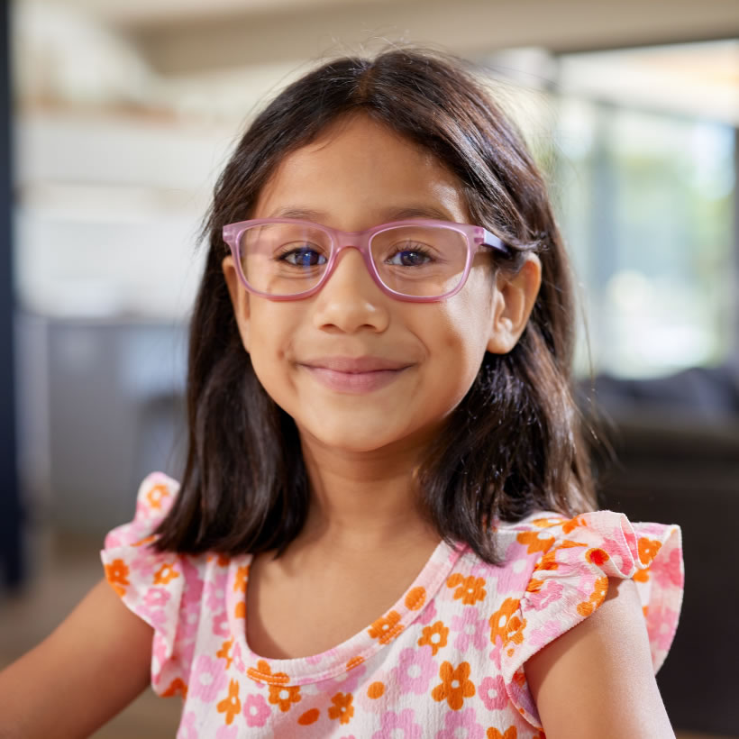 Girl in pink flowery dress wearing pink glasses