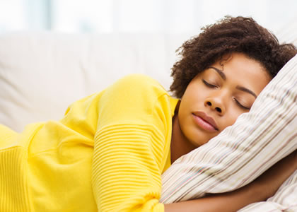 Woman in yellow jumper sleeping on her side