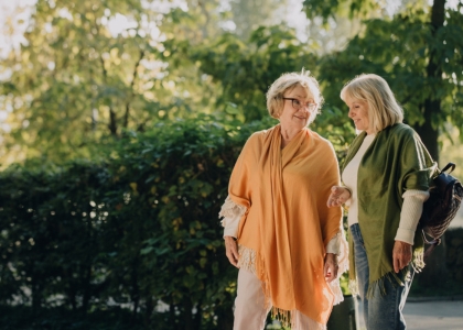 Two older women smiling together in a park