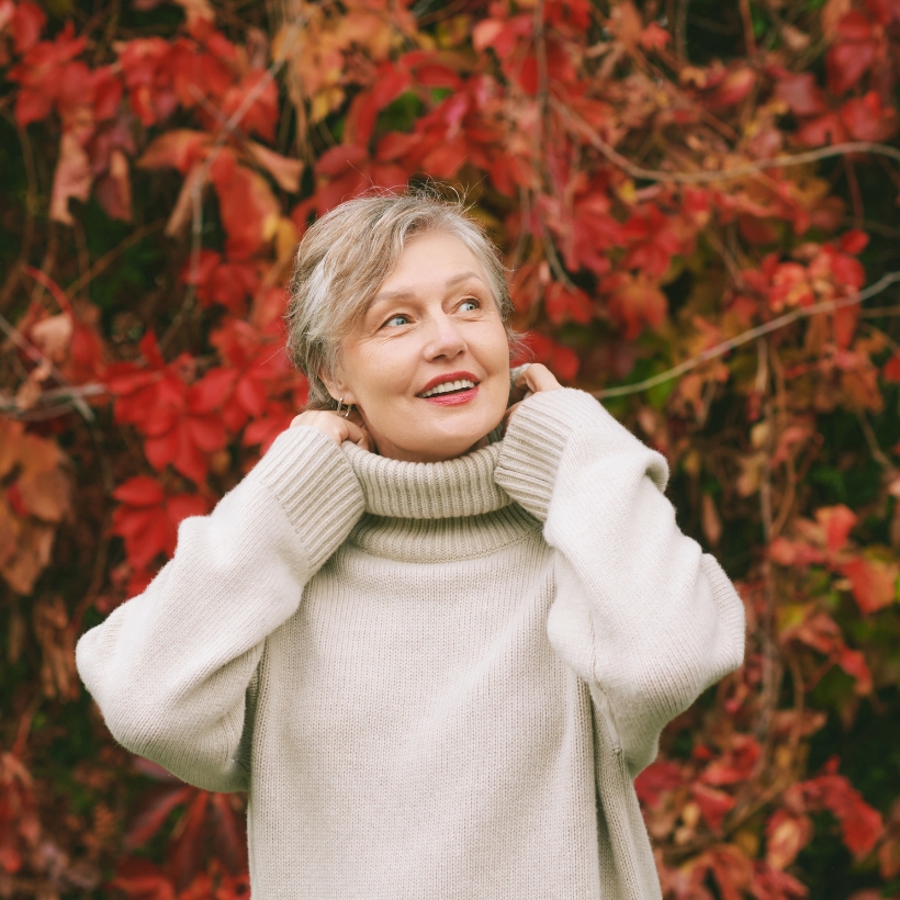 Older women in front of bush with red leaves