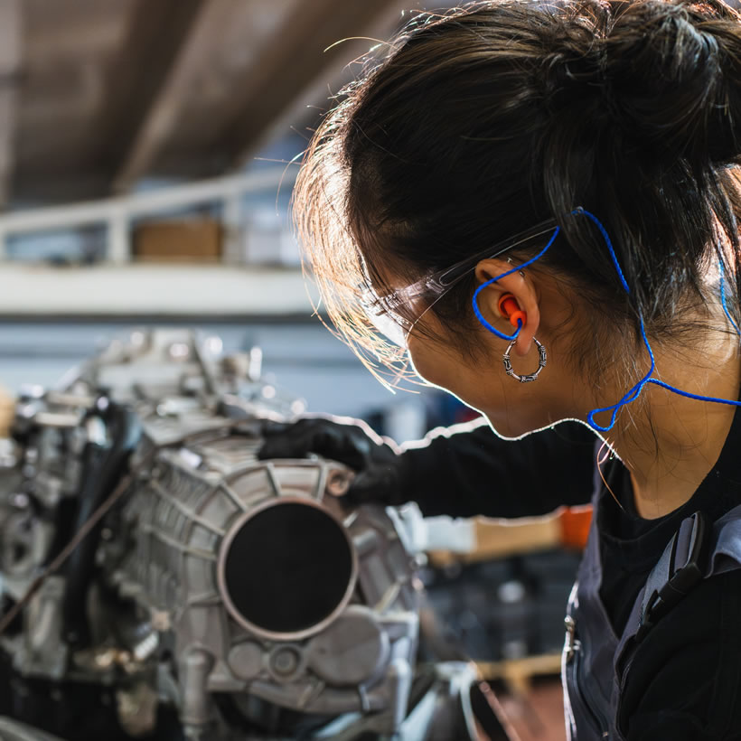 Woman working on engine in a factory