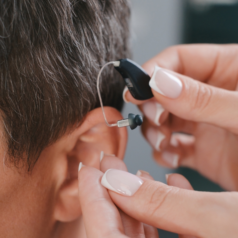 Hearing aid being put in ear