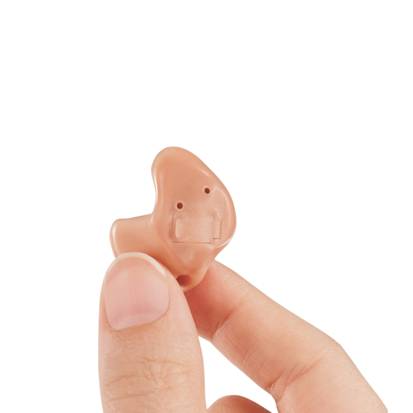 Hand holding ITE hearing aid