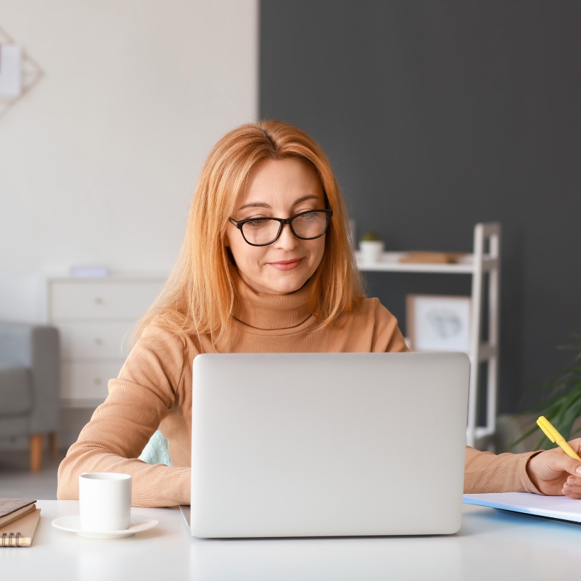 Lady sat at desk looking at laptop