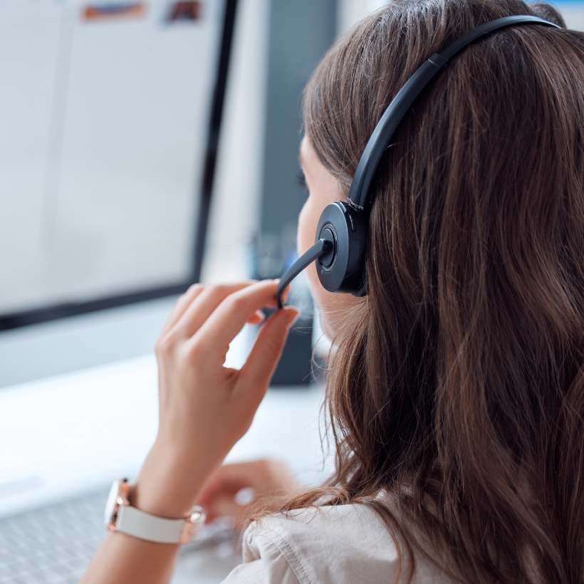 Lady looking at computer while wearing a headset