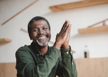 Man in green shirt holding his hands together