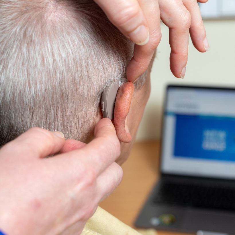 Middle aged man having hearing aids fitted in a Scrivens branch