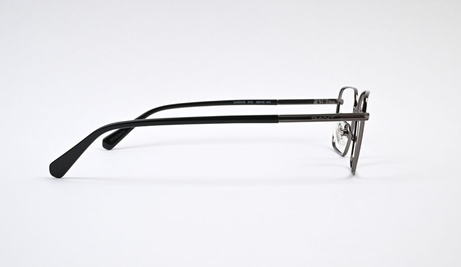 Side view of metal eyeglasses with black temple arms and a thin frame, brand name GANT on the temple.