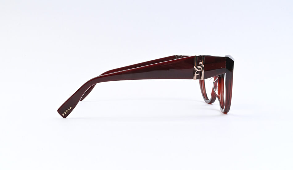 Side view of red-brown translucent sunglasses with a metal accent near the hinge and Furla logo on the temple