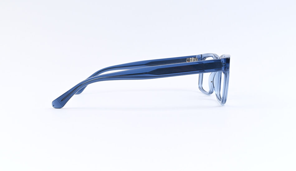Blue transparent eyeglasses lying on a white surface, side view