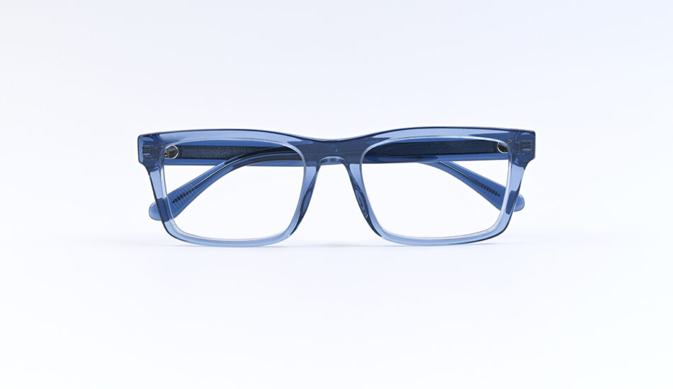 Blue rectangular eyeglasses with clear lenses lying on a white surface. An acetate frame in blue.