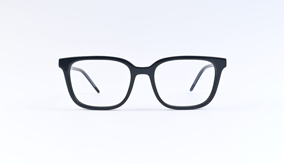 Black rectangular eyeglasses resting on a white surface.
