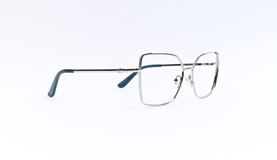Metal frame eyeglasses with blue temple tips on a white background, viewed from a slight side angle, minimalistic studio shot.