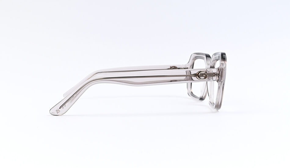 Clear plastic eyeglasses shown from the side, highlighting the temple design and hinges on a white background.